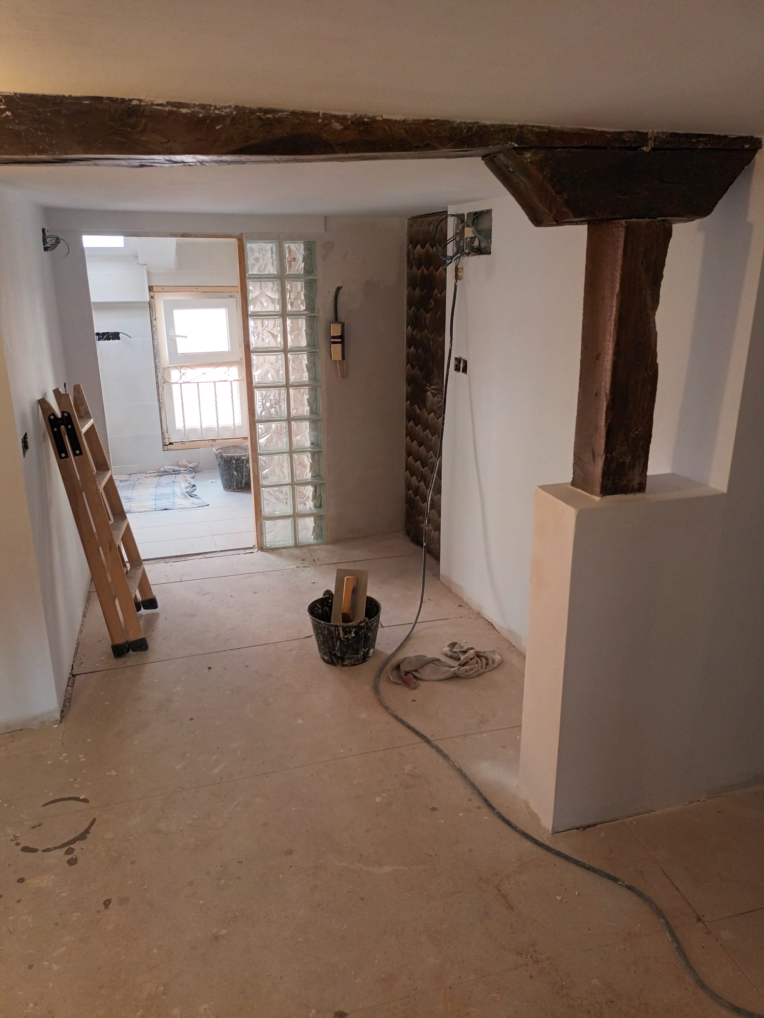 Reforma interior de vivienda con viga de madera restaurada en Santander